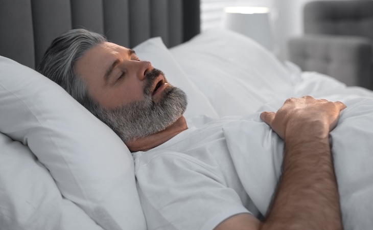 Man sleeping peacefully in bed.